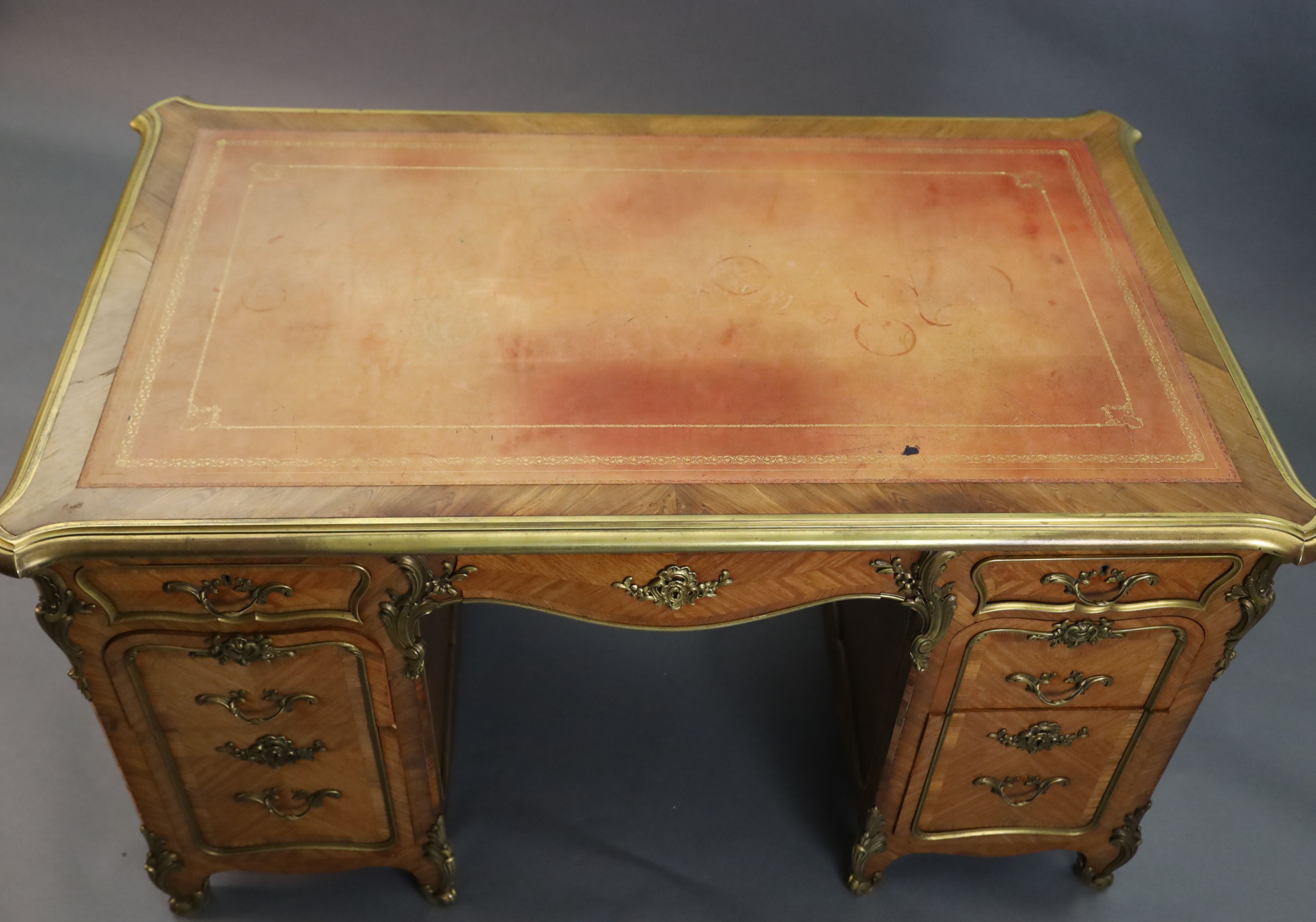 An early 20th century Louis XVI style ormolu mounted satinwood and rosewood kneehole desk, W.4ft 5in. D.2ft 8in. H.2ft 6in.